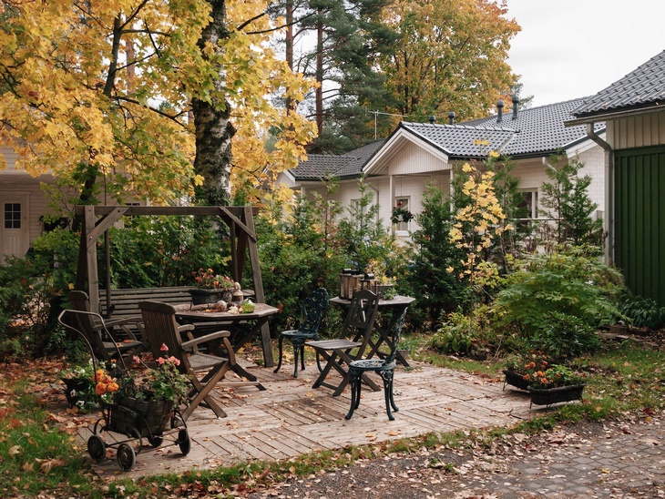 Деревянные качели, стол и стулья в саду